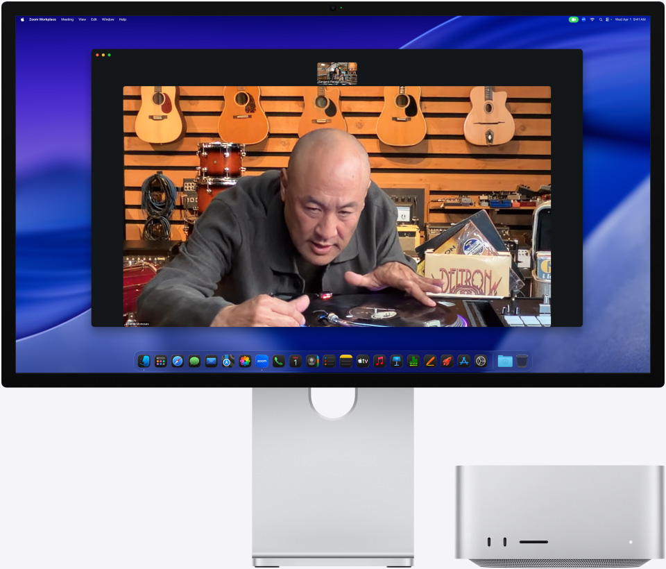 По време на видеоразговор на Studio Display XDR с Mac Studio отдолу, човек в музикален магазин разглежда отблизо грамофон