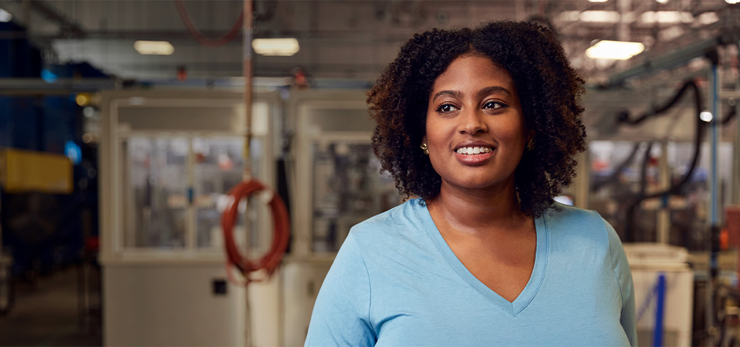 Photo de Camara dans le Laboratoire de récupération des matériaux. Elle sourit, le regard tourné sur le côté.