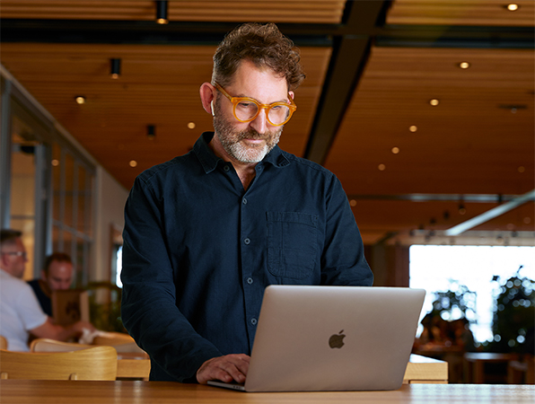 Una persona del equipo de Funciones corporativas de Apple usa un MacBook en el Caffè Macs.