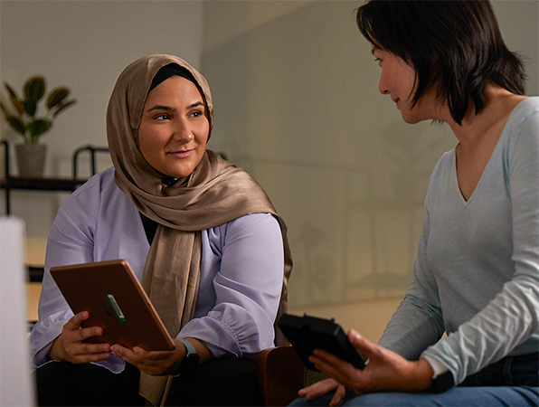 Dos personas del equipo de IA y aprendizaje automático de Apple colaboran, una de ellas con un iPad y la otra con un iPhone.