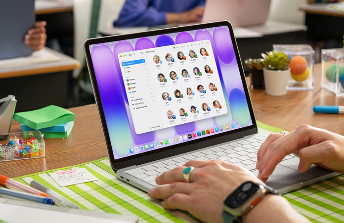 Una profesora sentada con un Mac abierto, la app Aula muestra la lista completa de estudiantes de la clase