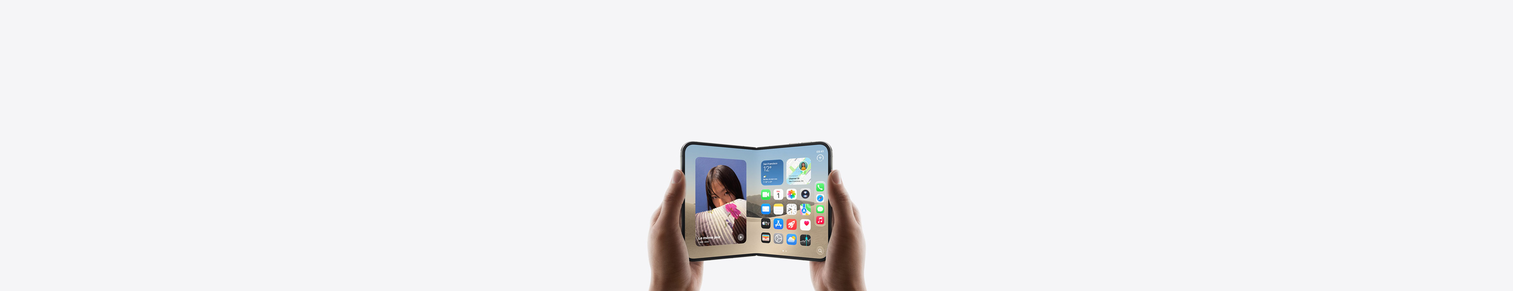 iPhone Duo, tenu par deux mains en mode paysage, déplié, écran interne affichant l’écran d’accueil.