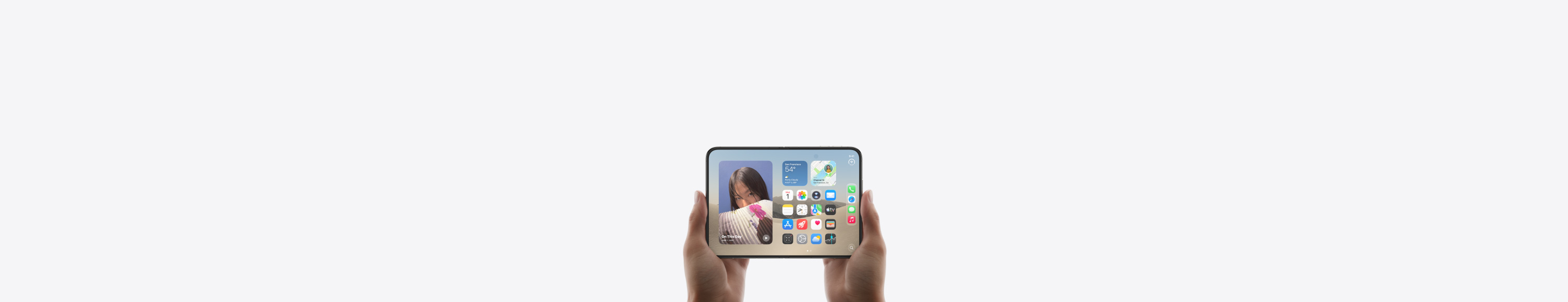 iPhone Duo, dipegang dengan dua tangan dalam orientasi lanskap, dibuka, layar interior menampilkan Layar Home