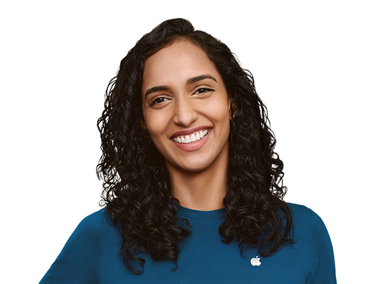 Showing an Apple Support Specialist smiling, wearing a blue shirt with an Apple logo on one side