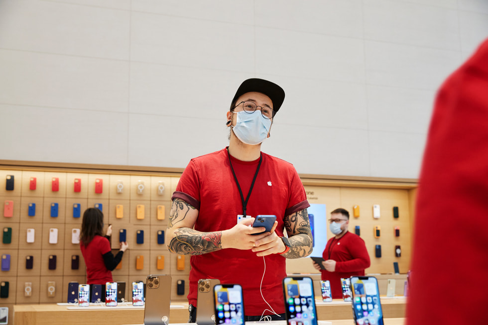 Ein Teammitglied von Apple Rosenheimer Straße richtet ein iPhone auf einem Tisch her.