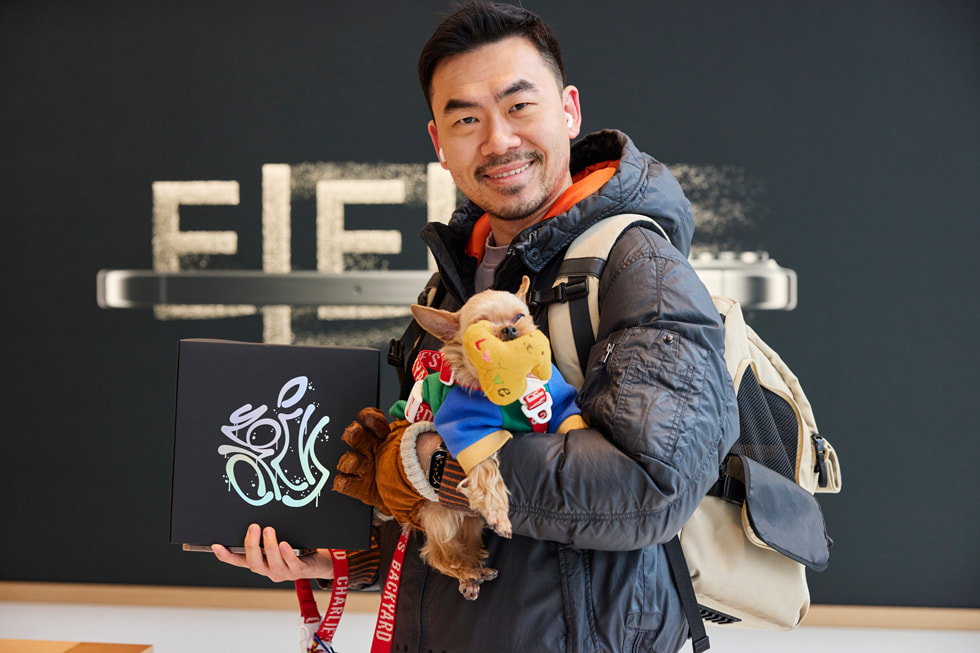 A customer holding a small dog shows off their swag.
