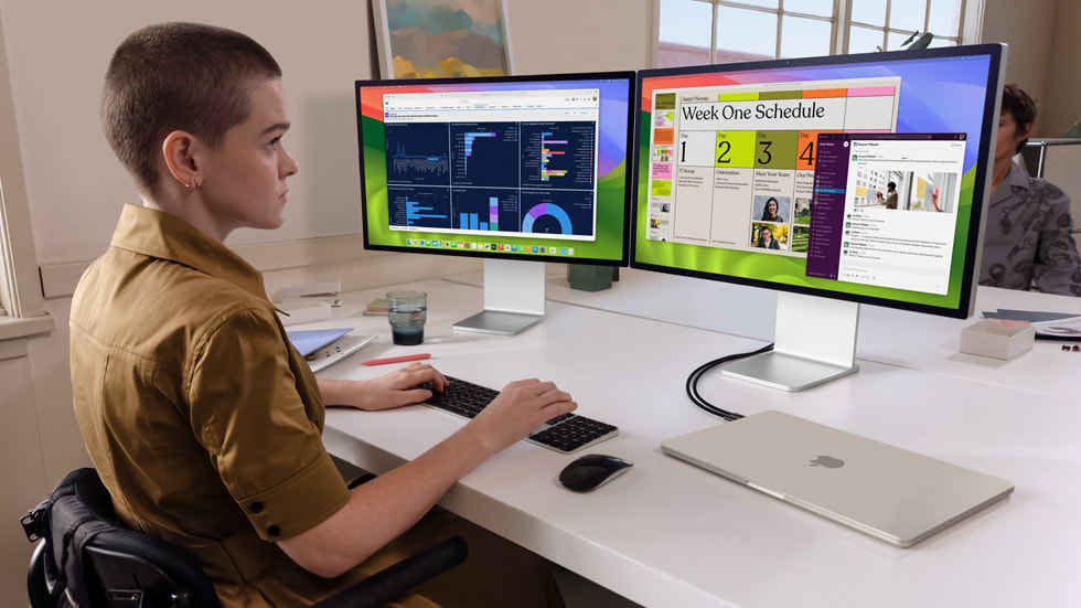 A person does some work on the new MacBook Air with two external displays.