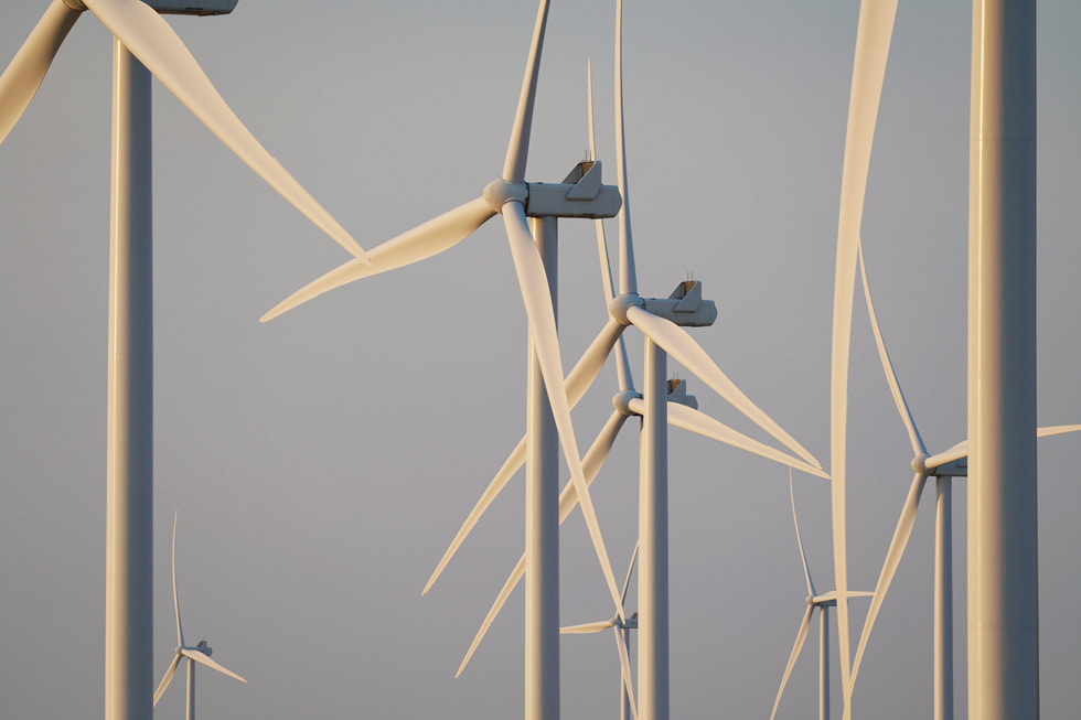 A wind farm in Oregon with multiple white turbines against a blue sky.