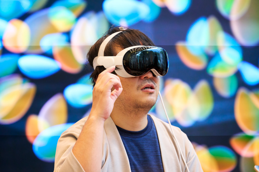 A customer holds his hand near his face while wearing Apple Vision Pro.