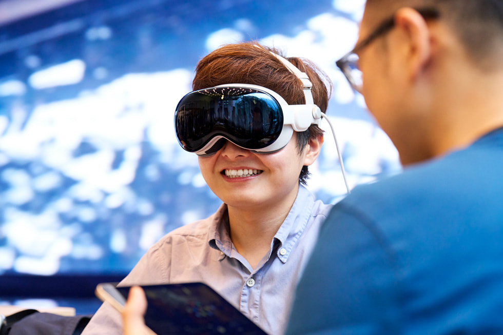 A customer in the Apple Omotesando Demo Zone smiles as a team member walks her through a demo.