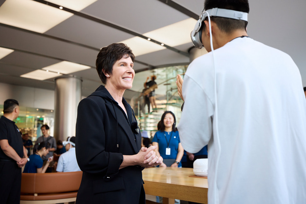 Deirdre O’Brien talks with a customer wearing Apple Vision Pro.
