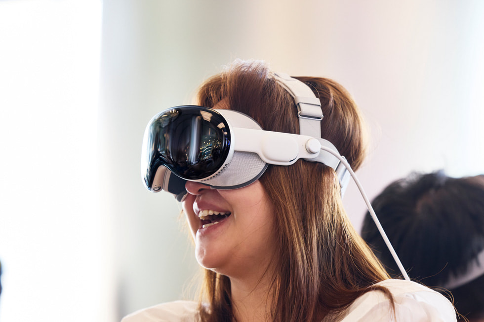 A customer wearing Apple Vision Pro inside Apple Wangfujing stares up toward the ceiling with an expression of awe.