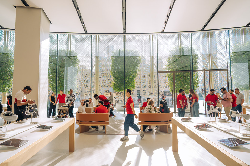 A zoomed-out interior shot of an Apple Store in the United Arab Emirates, bustling with customers and Apple team members.