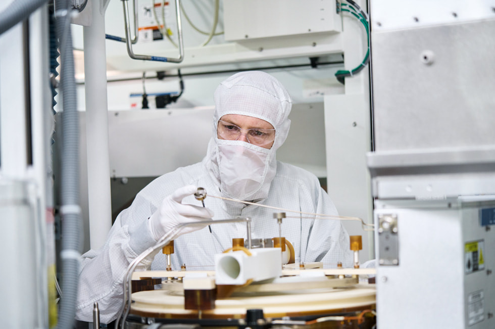 A worker in protective gear at a Texas Instruments manufacturing facility.