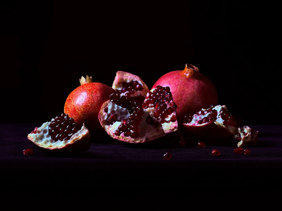 A detailed close-up of a pomegranate and its seeds, shot on iPhone 17 Pro.