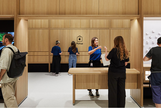 An Apple team member chats with a customer at the Pickup counter inside an Apple Store.
