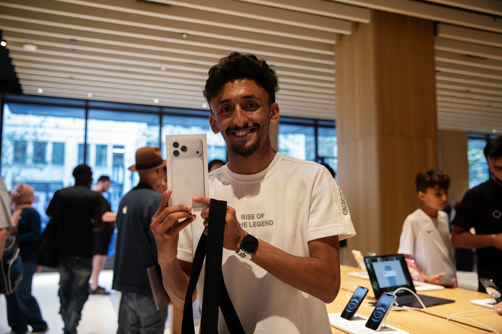 A customer poses with iPhone 17 Pro in silver at Apple Downtown Detroit.