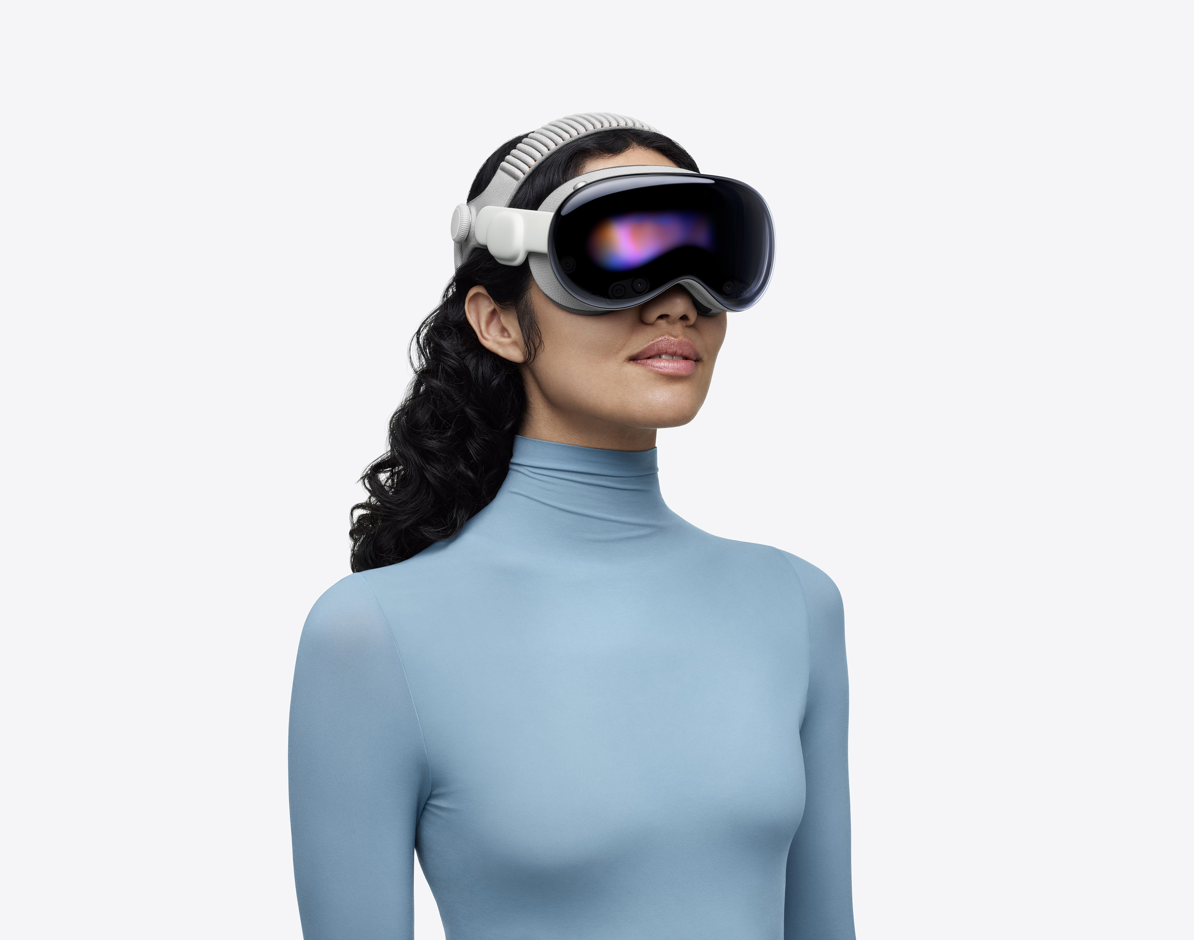 M5 칩과 듀얼 니트 밴드를 탑재해 업그레이드된 Apple Vision Pro를 착용한 파란색 터틀넥을 입은 여성의 모습.
