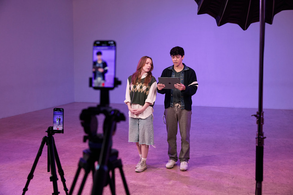 Two iPhone 17 Pro Max devices on stands record Kyle Hanagami and a dancer in a studio setting. Hanagami holds an iPad Pro.