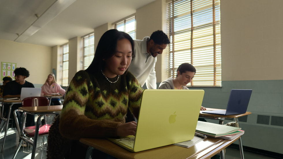 A student uses their citrus MacBook Neo in a classroom setting.