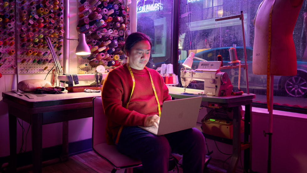 A person in textile studio works on MacBook Neo.