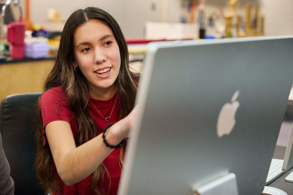 ภาพของ Melissa Fourkiller ขณะนั่งอยู่หน้าเครื่อง iMac ในห้องเรียน
