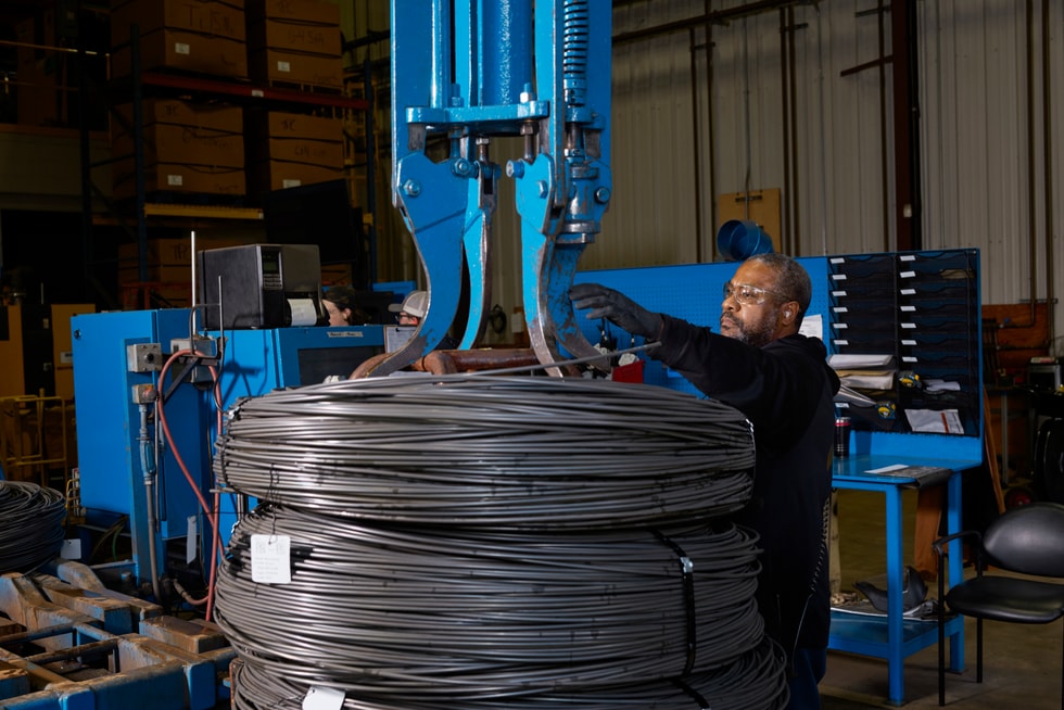 A Perryman Company worker inspects spools of titanium.