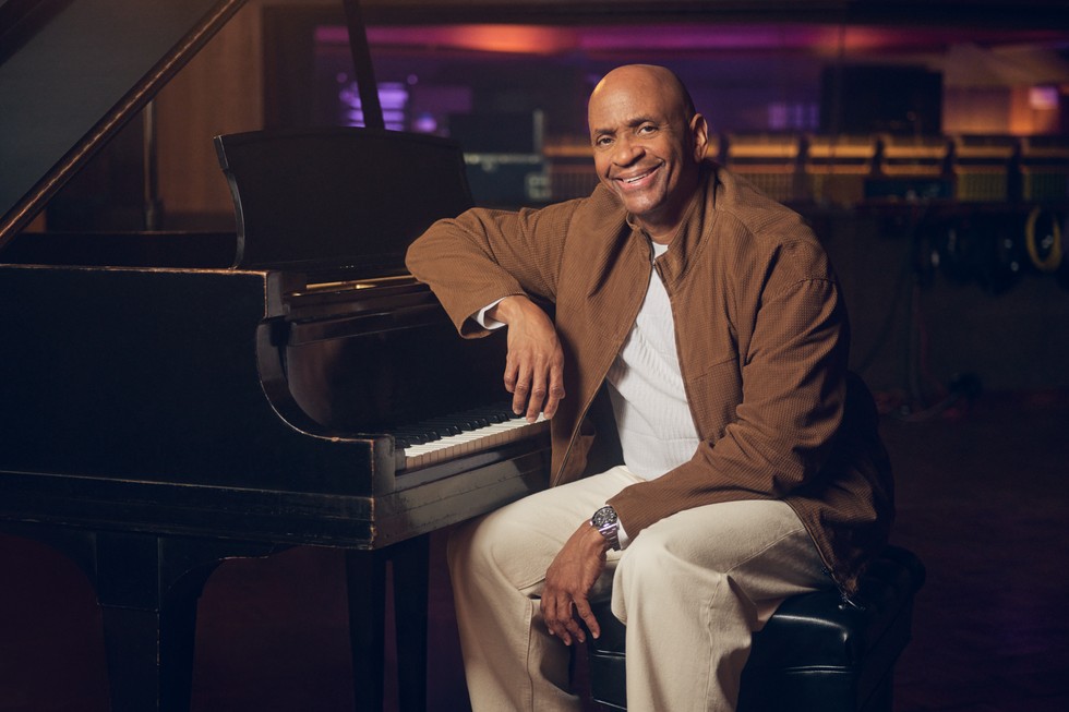 Sergio George sitting at a piano.