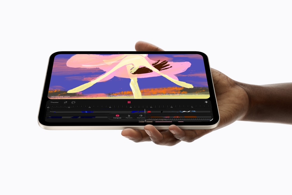 iPad mini, held in a person’s hand, shows a Procreate Dreams screen.