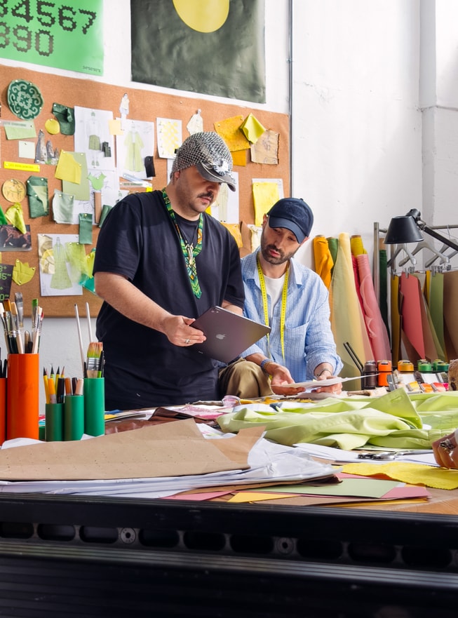 Bünyamin Aydın is pictured holding iPad Pro alongside a team member in his studio.