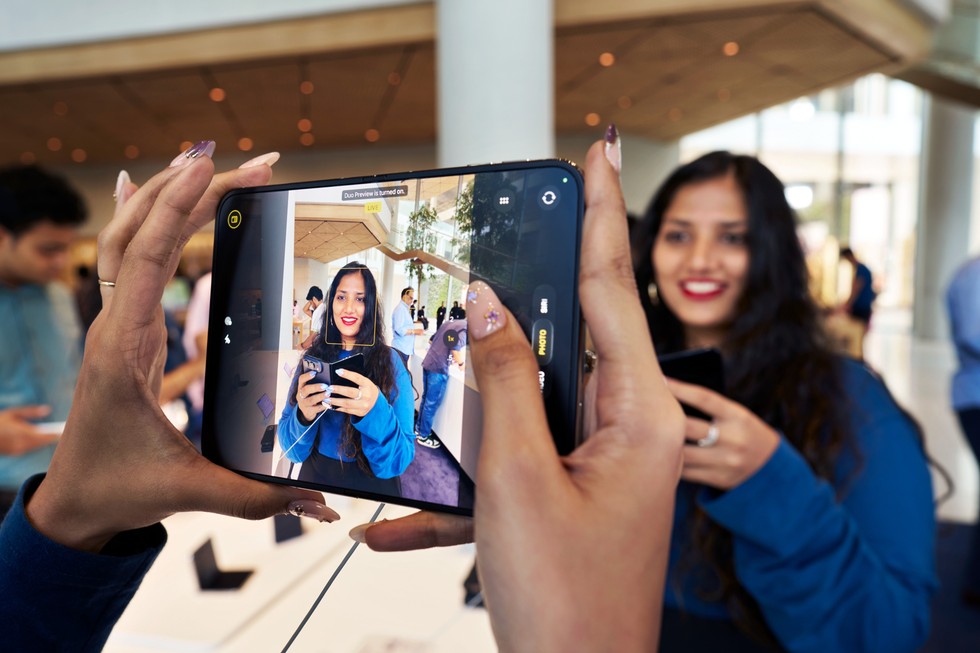 At Apple BKC, a customer uses iPhone Duo to take a photo of another customer.