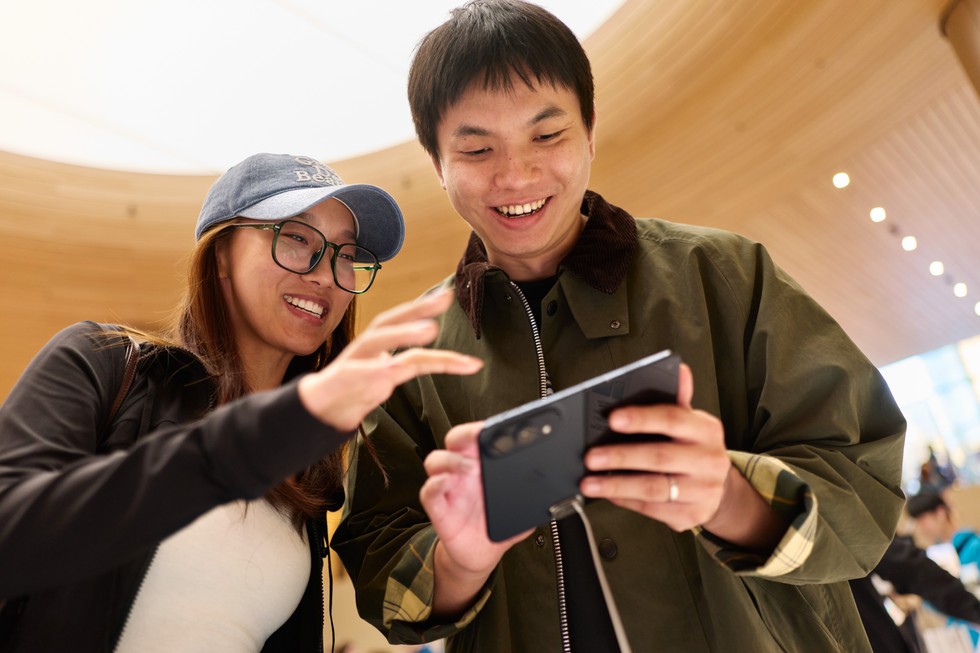Two customers try out iPhone Duo in night sky at Apple Jing’an.