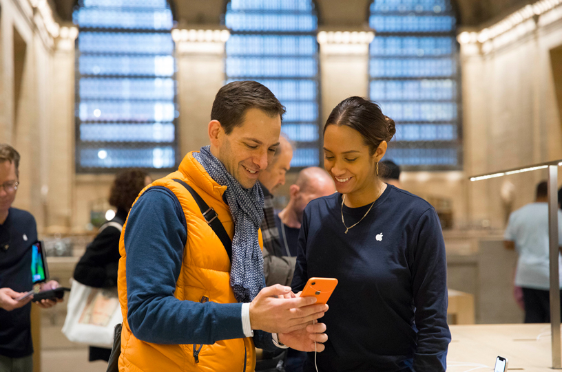 An Apple Grand Central team member assisting a customer with the iPhone XR.