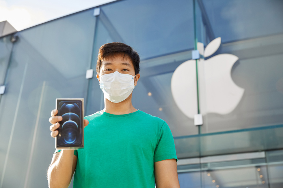 A customer outside Apple Highland Village shows off his new purchase.