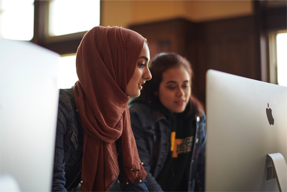 High school students working behind a Mac.