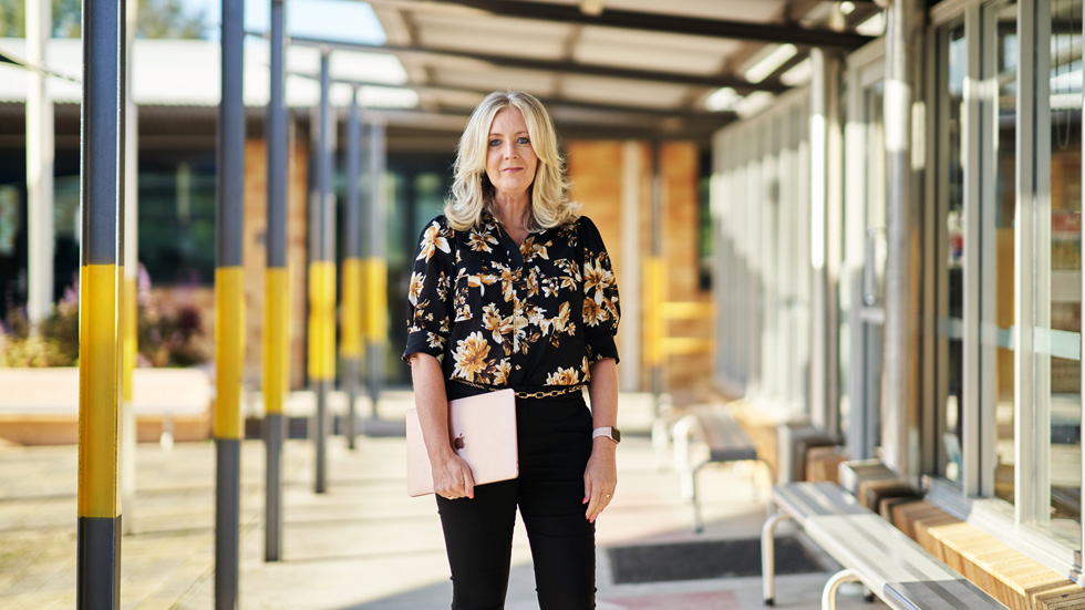 Michelle McKinnon carrying a rose gold MacBook Air.