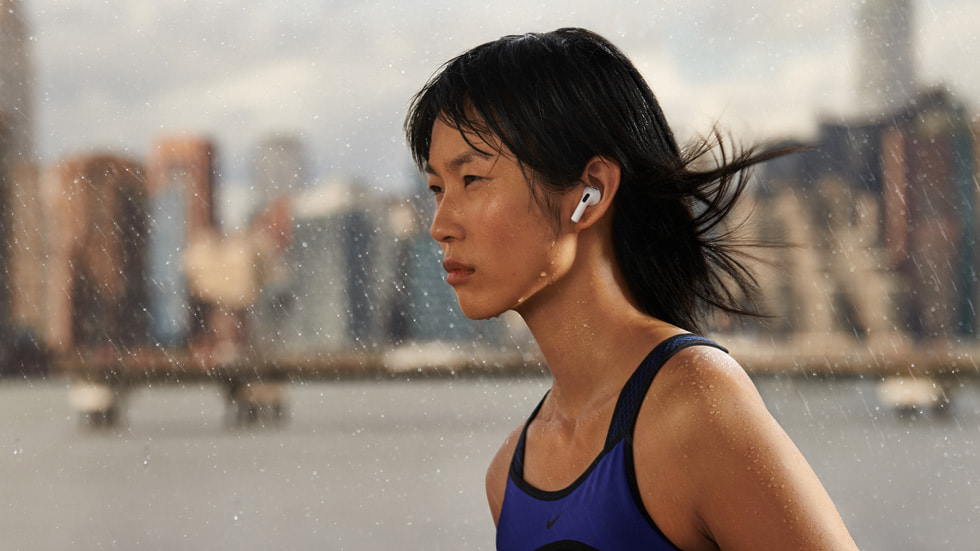 A woman wearing AirPods (3rd generation) in the rain.