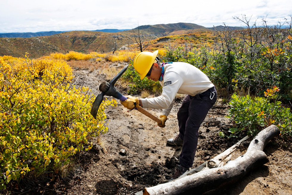 A member of the Mesa Verde Conservation uses an pickaxe in a national park.