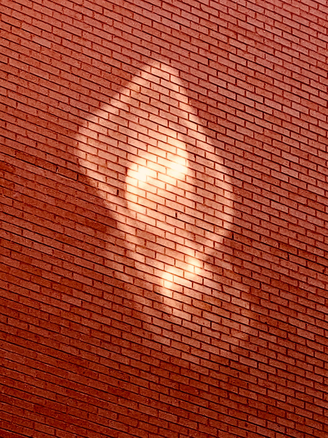 A photo of a brick wall with light reflections shot on iPhone 11 Pro Max by Axel Morin in Paris, France.