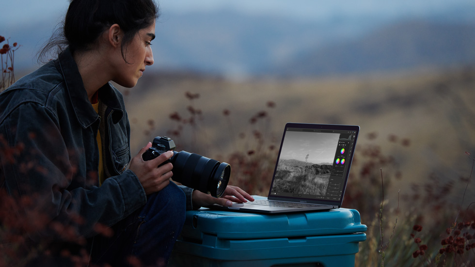 A photographer using her camera and M1-powered MacBook Air.