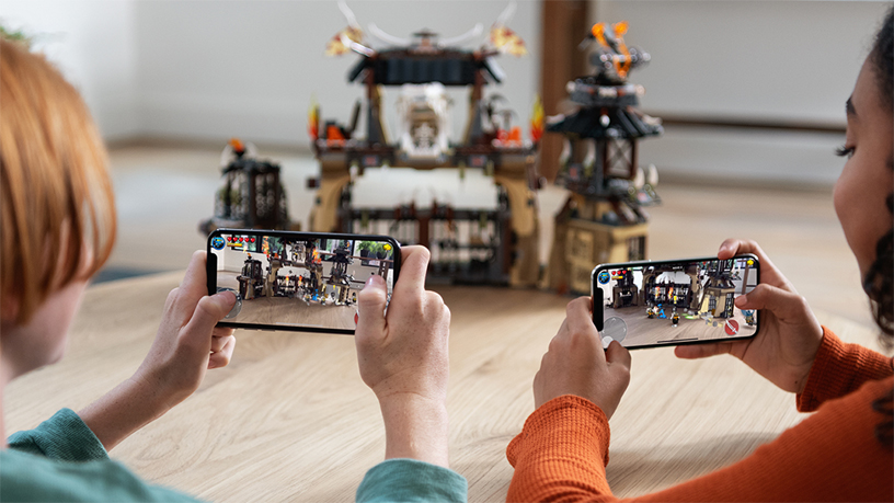 Two kids playing an iPhone AR game.