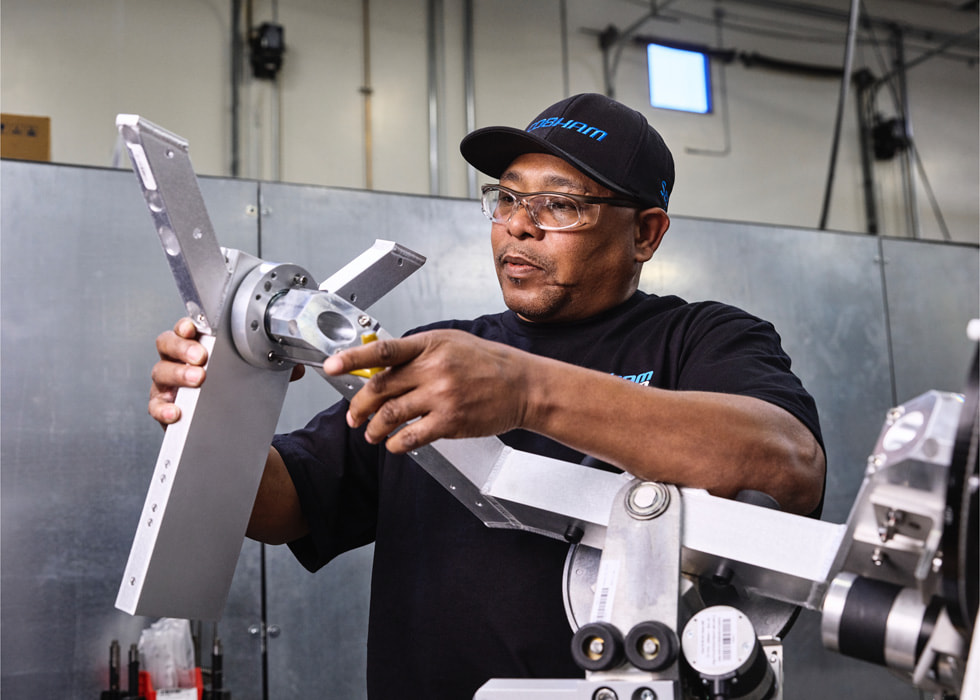 A technician is shown working on satellite machinery.