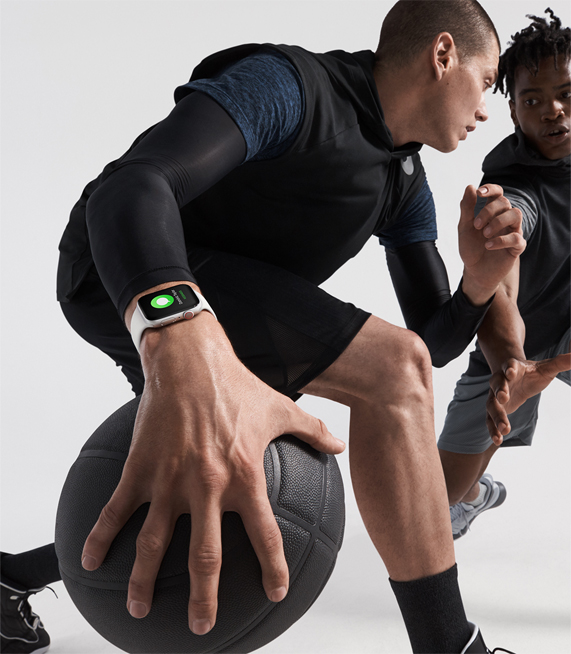 Two men playing basketball, wearing Apple Watch Series 4. 