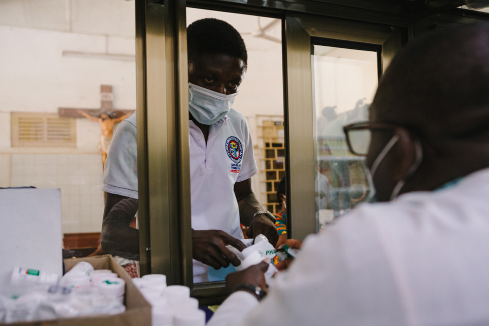 Model of Hope program volunteer Joseph picking up antiretroviral therapy medications.