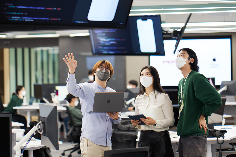 대한민국 포항시에 개소한 Apple Developer Academy 교실에 앉아 대화하고 있는 학생 및 교육자의 모습.