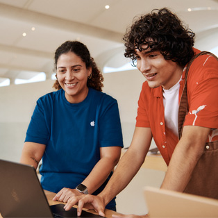 Bir müşteri ve yanındaki Apple Store çalışanı birlikte bir MacBook kullanıyor.