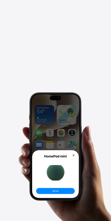 En hånd holder en iPhone, der viser appen Hjem med en meddelelse om indstilling af intelligent tilbehør i hjemmet
