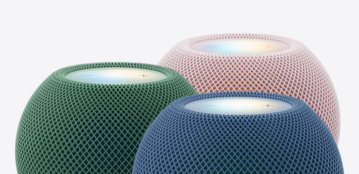 三部綠色、藍色和粉紅色 HomePod mini 2 揚聲器的頂部外觀特寫，展示編織聲學網狀織物和發光的觸控表面