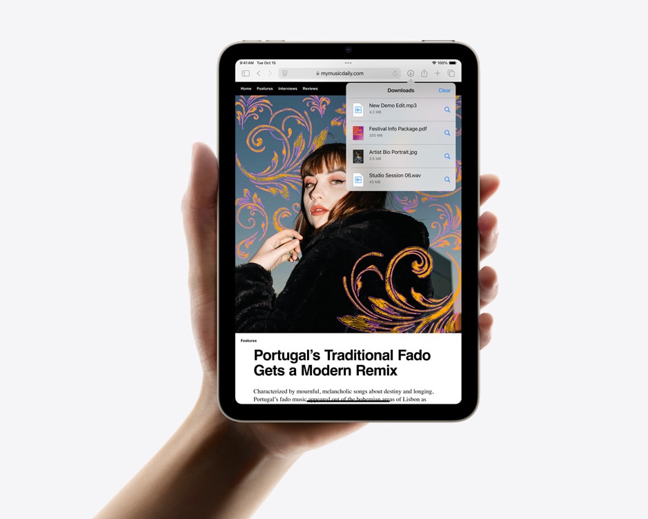 Vertikāli novietots iPad mini vienā rokā, demonstrējot Safari lejupielādes.